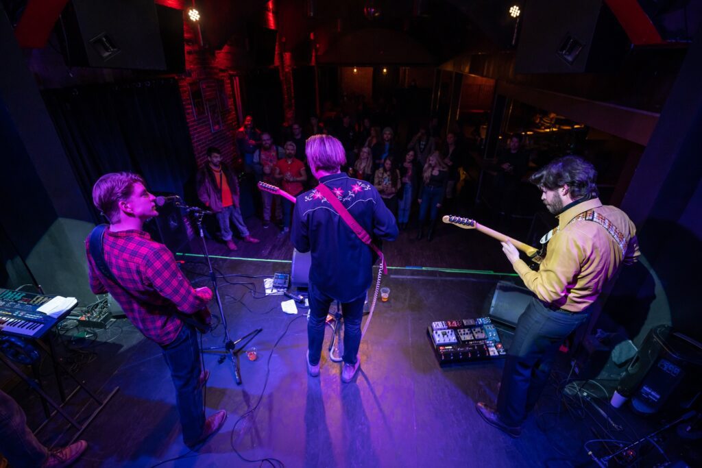 Band performing on stage in dim lighting.