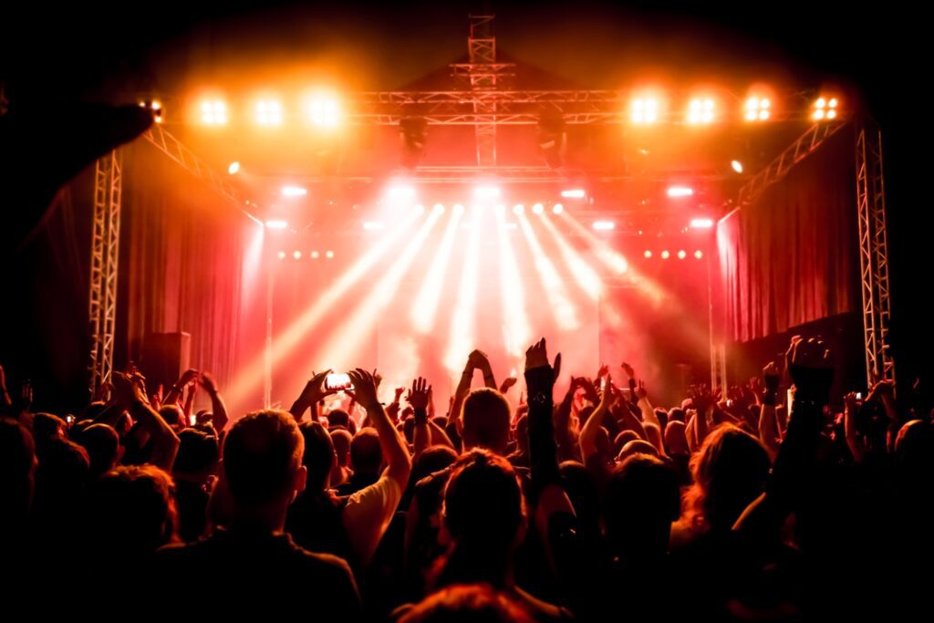 Concert crowd under bright stage lights.